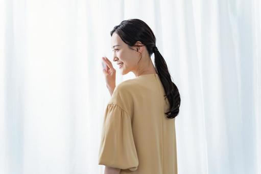 カーテンに手を添える女性 ストレッチ,リラックス,女性の写真素材