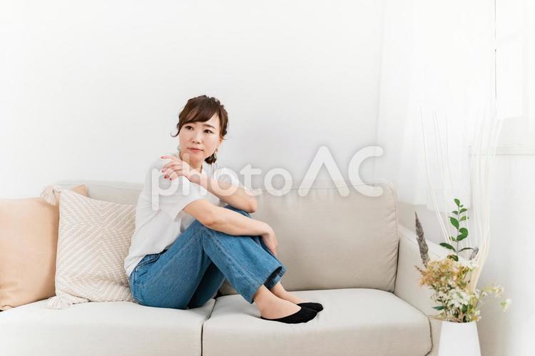 家のソファで落ち込む日本人女性（考える） 考える,暇,退屈の写真素材
