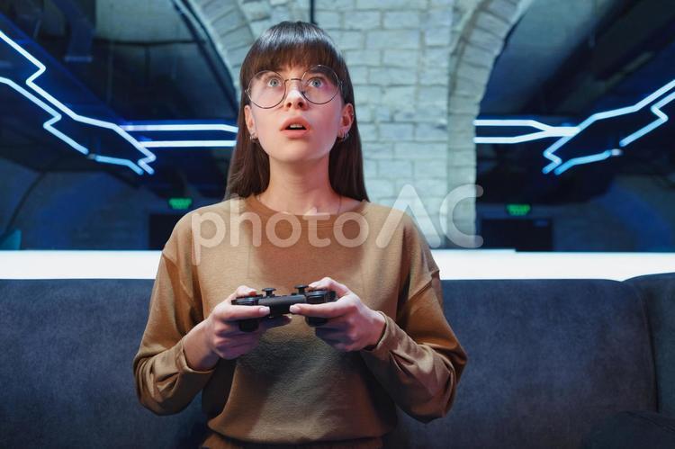 黒のコントローラーを持っているメガネの女性 ゲーマー,人物,女性の写真素材