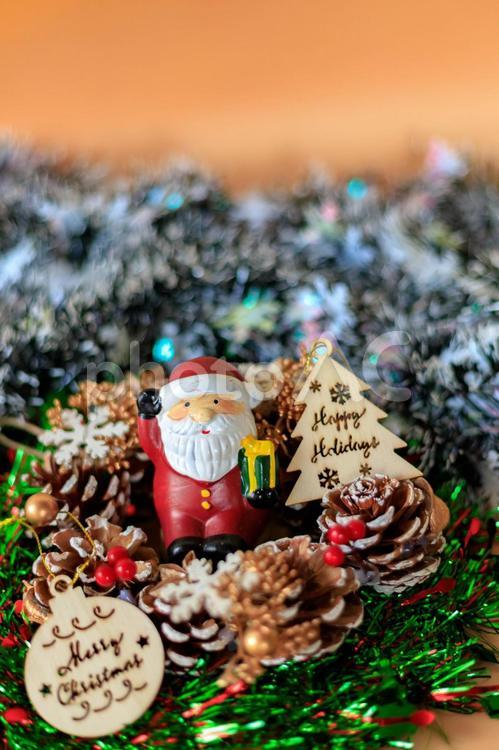 サンタクロースの置物とクリスマスイメージ チャーム,リース,松ぼっくりの写真素材