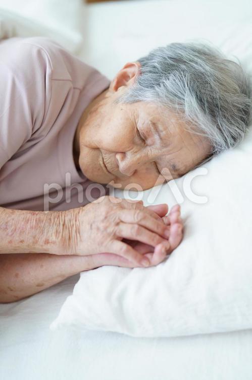 枕に手を置き寝ている高齢女性の寝顔 女性,寝る,目を瞑るの写真素材