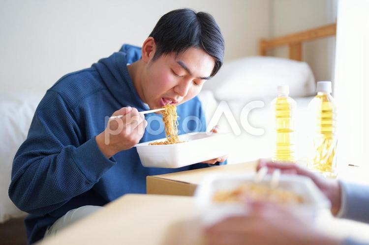 引っ越しの合間にカップ焼きそばを食べる2人の男性 引っ越し,一人暮らし,男性の写真素材