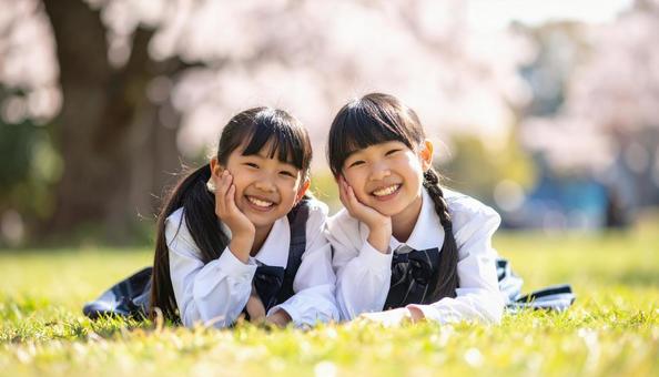 芝生に寝っ転がって笑顔の日本人姉妹 芝生に寝っ転がって笑顔の日本人姉妹の写真