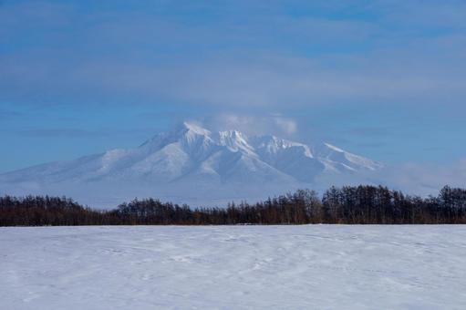 険しい山肌を見せる冬の斜里岳 険しい山肌を見せる冬の斜里岳 斜里岳,青空,雪山の写真素材