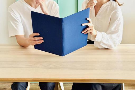 資料やアルバムを見て考える男女の夫婦 資料やアルバムを見て考える男女の夫婦 夫婦,カップル,相談の写真素材
