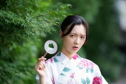 浴衣姿の女性がやぶれたホイを持つ 女性,浴衣,ポイの写真素材