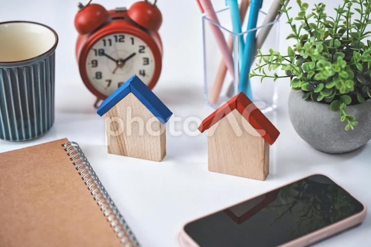 2つの木製の家とスマホと雑貨 家,住宅,ローンの写真素材