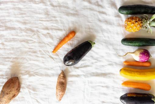 白い布に並ぶ野菜やフルーツ 白い布に並ぶ野菜やフルーツの写真