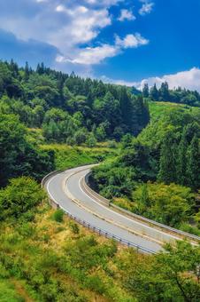 夏、晴れた日のカーブした道路 夏、晴れた日のカーブした道路 山道,カーブ,道路の写真素材