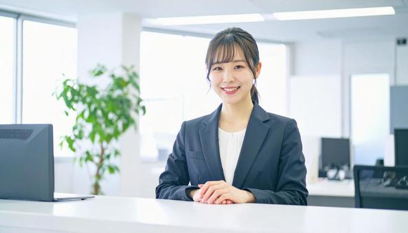笑顔で対応する女性の受付嬢 笑顔で対応する女性の受付嬢の写真
