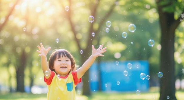 シャボン玉で遊ぶ笑顔の男の子 シャボン玉で遊ぶ笑顔の男の子の写真