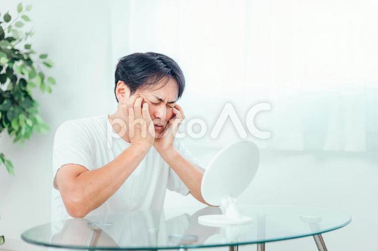 鏡を見て悩む男性 スキンケア,肌荒れ,トラブルの写真素材