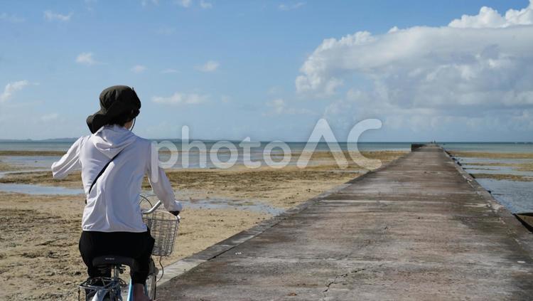 桟橋を自転車に乗って走る女性 自転車,女性,桟橋の写真素材