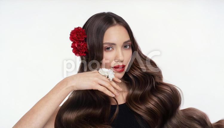 赤い花の飾りを付けたロングヘアの女性 女性,カーネーション,髪の写真素材