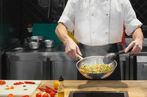 フライパンで野菜を調理している男性シェフ フライパンで野菜を調理している男性シェフ キュイジーヌ,キッチン,厨房の写真素材