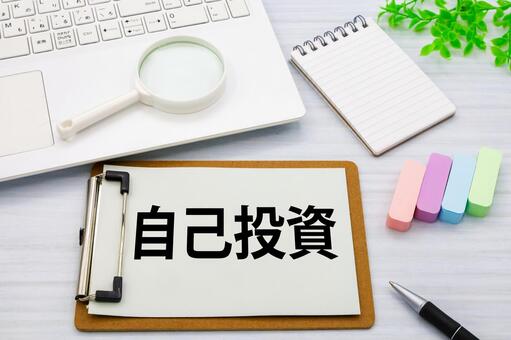 自己投資の文字とビジネスデスク 自己投資,クリップボード,パソコンの写真素材
