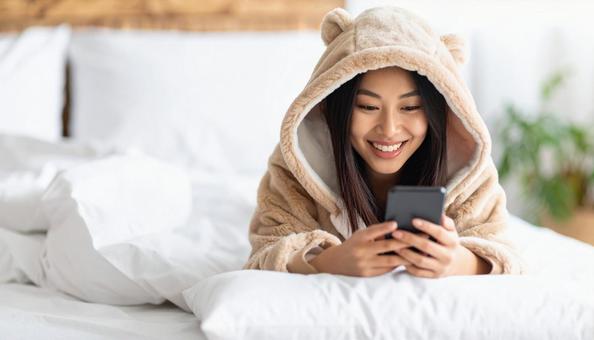 スマホを見て笑う女性 スマホを見て笑う女性の写真