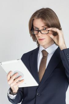 タブレットを使うカメラ目線のスーツの男性 男性,外国人,欧米人の写真素材