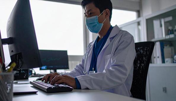 病院で電子カルテに入力する男性の手もとの写真