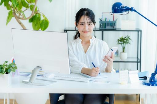 オフィスでスマホを持つビジネスウーマン スマホ,笑顔,ビジネスウーマンの写真素材
