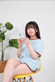 部屋着でスマートフォンを操作する女性 部屋着でスマートフォンを操作する女性 女性,若い,20代の写真素材