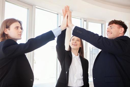 ハイタッチをするスーツの外国人3人 男女,外国人,ビジネスの写真素材