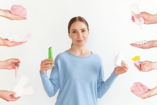 生理用ナプキンとタンポンを手に持つ女性といろいろな生理用品 生理,月経,女性の写真素材