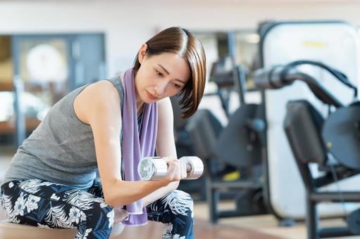 ジムでトレーニングするミドルの女性 ジム,女性,ダンベルの写真素材