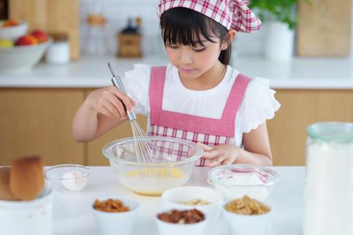 お菓子作りの材料を前に調理をする少女 女の子,小学生,日本人の写真素材