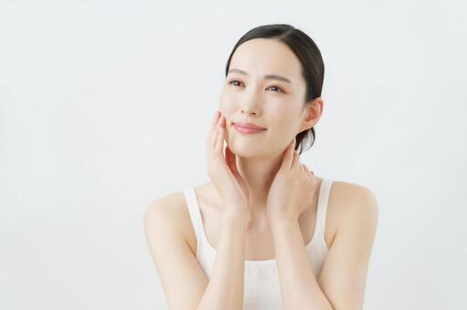 頬に手を当てる若い女性のスキンケア 女性,スキンケア,ビューティの写真素材