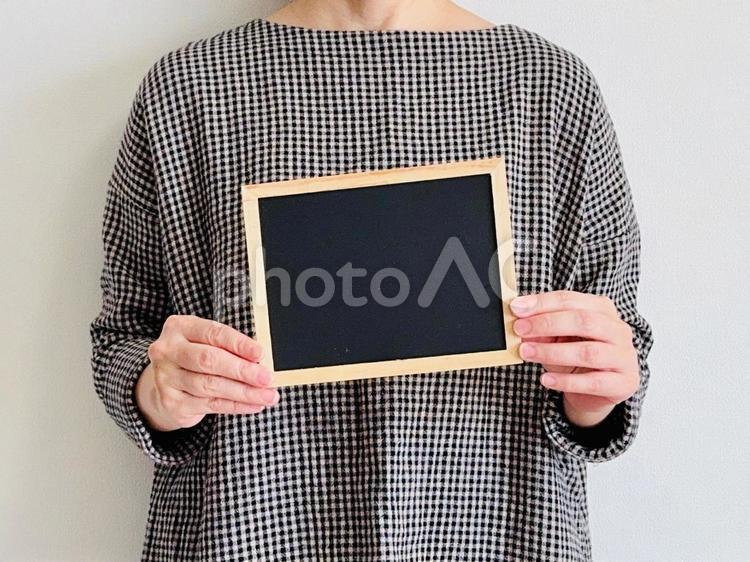 黒い小さなボードを持つ女性 黒板,ボード,お知らせの写真素材