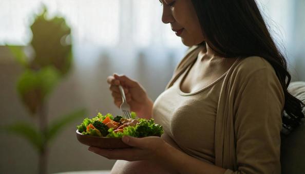 食事を美味しそうに食べる妊婦 食事を美味しそうに食べる妊婦の写真