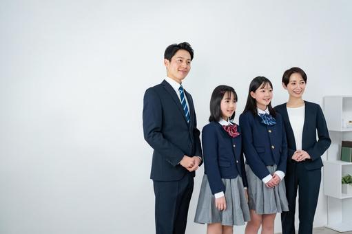スーツを着た男女と制服を着た女の子二人 スーツを着た男女と制服を着た女の子二人 入学式,父母,母親の写真素材