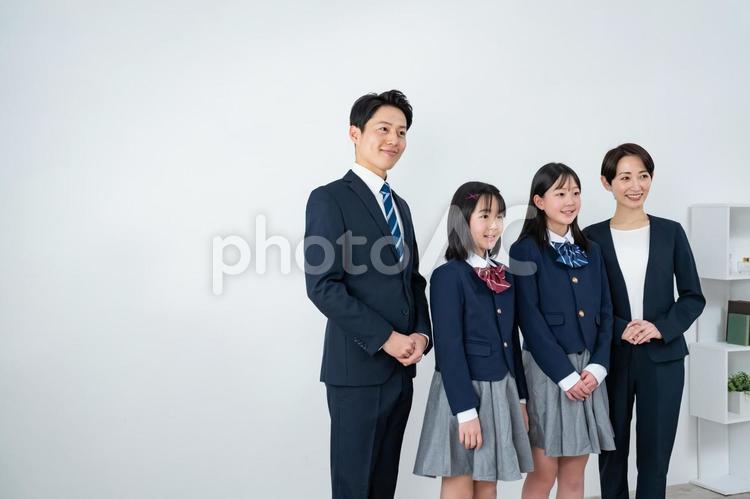 スーツを着た男女と制服を着た女の子二人 入学式,父母,母親の写真素材