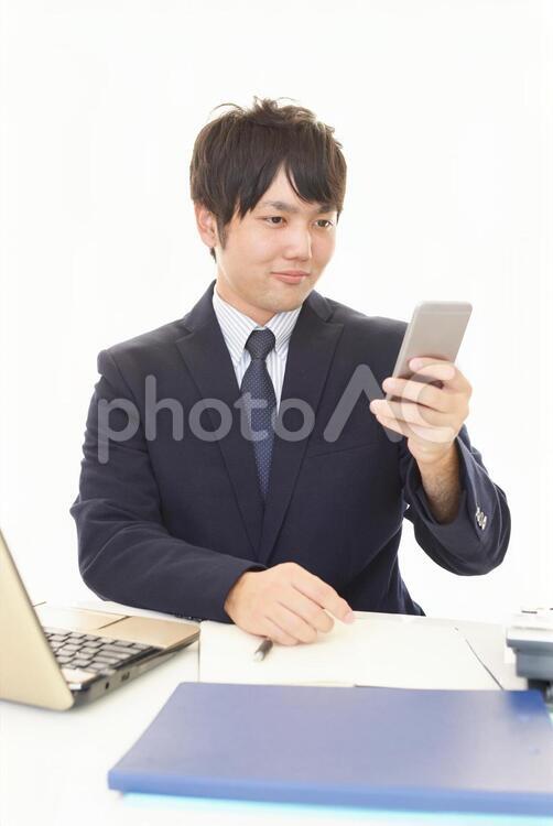 スマートフォンを持つビジネスマン 男性,ビジネスマン,男の写真素材