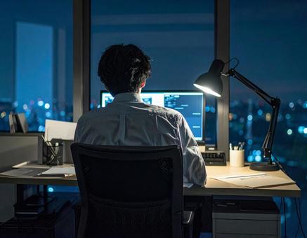 残業が終わらず作業する男性の写真