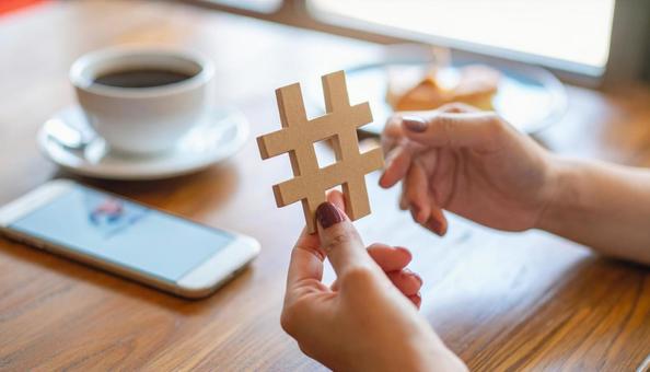 ハッシュタグを指でつまむ日本人女性の手の写真