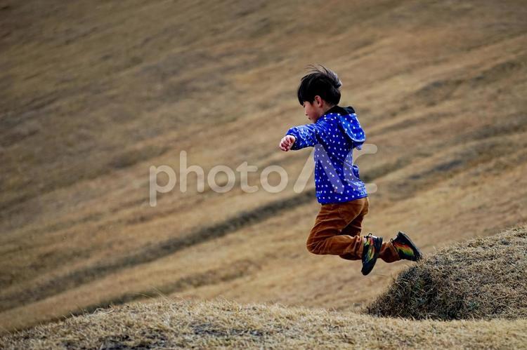 ＜素材＞冬の山の上で丘を飛び越える男の子 子供,男性,人物の写真素材