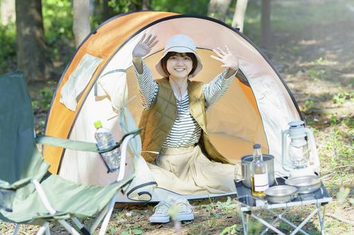 Solo camp image-A young woman waving with a smile from inside the tent, trại, cắm trại solo, đàn bà, JPG