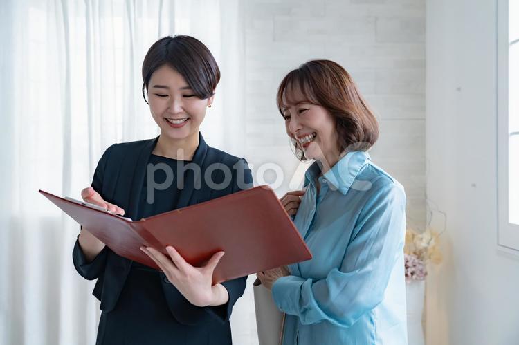 シニア女性とスーツを着た女性 レシェプション,受付,ビジネスウーマンの写真素材