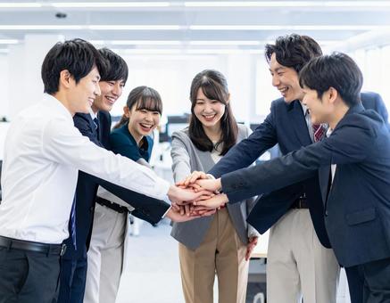 オフィスで円陣を組んでチームワーク醸成 オフィスで円陣を組んでチームワーク醸成の写真