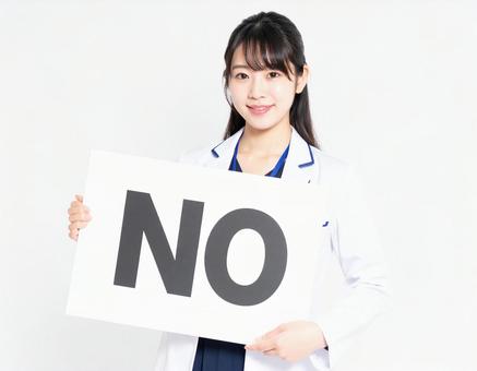 Noと書かれたボードを持つ女性社員 Noと書かれたボードを持つ女性社員の写真