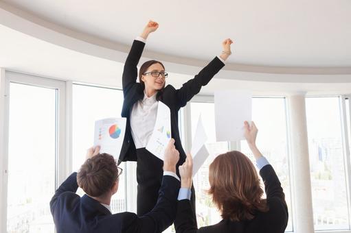 踊る女性に書類を見せている男性たち 女性,男女,外国人の写真素材