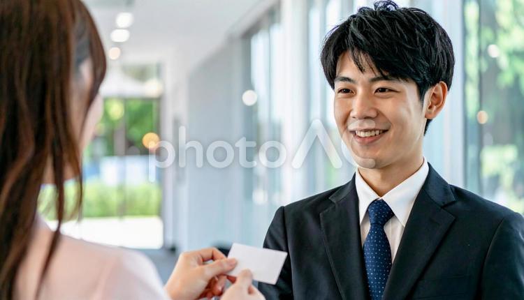笑顔で名刺を差し出す男性社員 ビジネス,名刺,名刺交換の写真素材