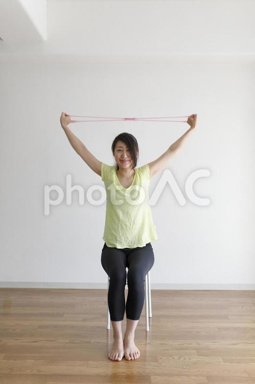 ゴムチューブを使ってストレッチ運動をする女性 女性,人物,日本人の写真素材