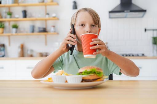 A boy drinking coffee and talking on the phone while looking at the camera, boy, people, hamburger, JPG