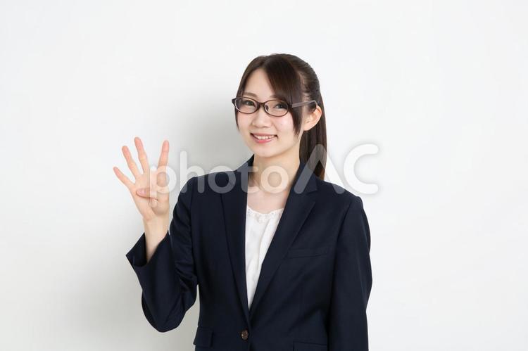 笑顔で指を４本立てているメガネのビジネスウーマン 女,女性,日本人の写真素材
