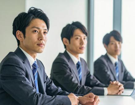 真剣な表情で会議に臨む若手ビジネスマン 真剣な表情で会議に臨む若手ビジネスマンの写真
