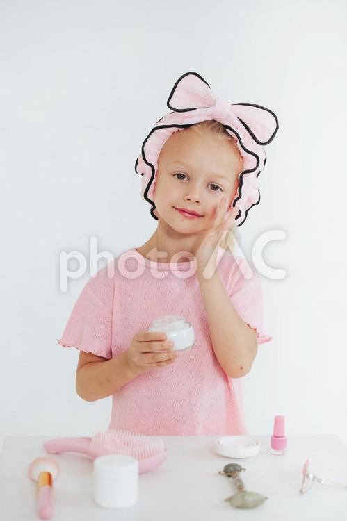 頬にクリームを塗る女の子 女の子,美容,ヘアバンドの写真素材
