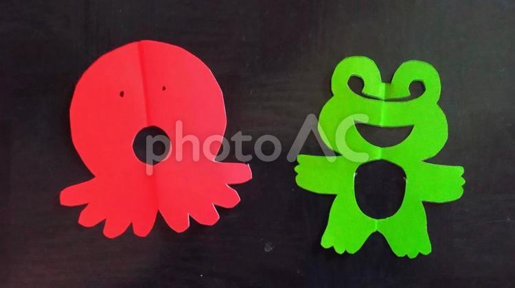 切り紙のたこ&カエル 楽しい,かわいい,黒いテーブルの写真素材